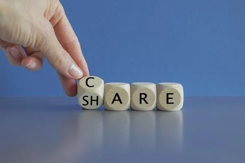 Hand turns a cube and form the words CARE and SHARE. Stock-Fotos
