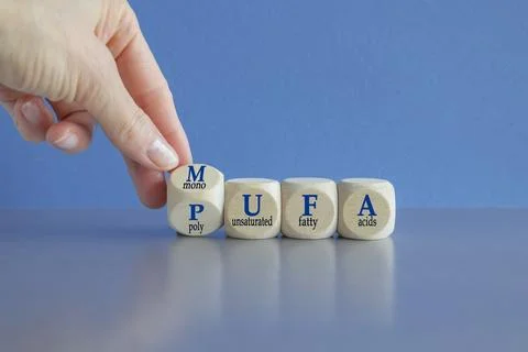 Hand turns a cube and form the acronym MUFA  and PUFA Stock Photos