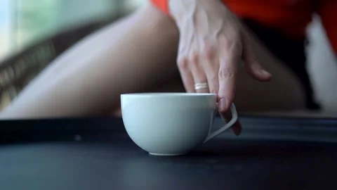 Hand turns a cup of coffee in a circle Stock Footage 220644798
