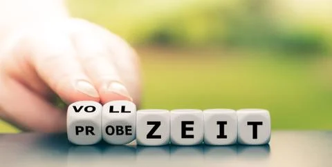 Hand turns dice and changes the German expression "Probezeit" ("probation per Stock Photos
