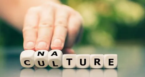 Hand turns dice and changes the word "culture" to "nature". Stock Photos