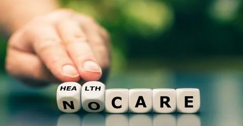 Hand turns dice and changes the expression "no care" to "health care". Stock Photos