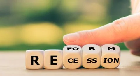 Hand turns dice and changes the word "recession" to "reform". Stock Photos