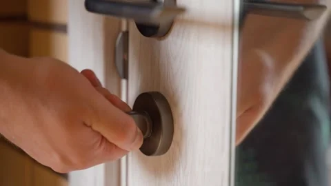 A hand turns the door lock and opens the door in the room, close-up. Stylish 動画素材 285820180