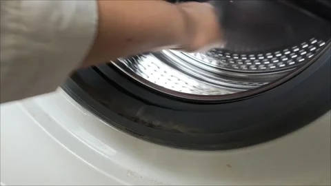 A hand turns the drum of the washing machine. Video stock 311992718