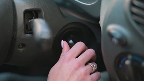 A hand turns the ignition key to start the car engine. The dashboard lights 库存影片 337643261