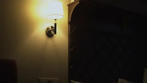 Hand turns off night light on the wall in front of dreams in the apartment room Stock Footage 146512702