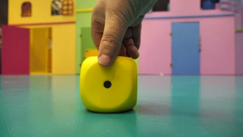 A hand turns over a large cube with the number two, five, six on the floor Stock Footage 277623360