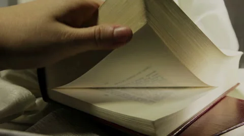 A hand turns the pages of a book which then closes, still life. Stock Footage 62051764