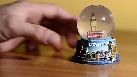 Hand turns a snow globe dedicated to the city of London Stock Footage 69755255
