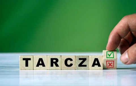 Hand turns the wooden cube and changes the polish word TARCZA (english shield Stock Photos