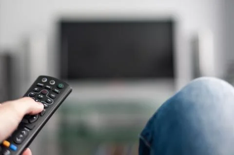 Hand with TV remote control 스톡 사진