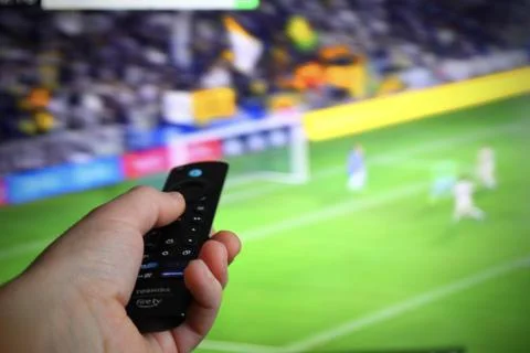Hand with TV remote control 写真素材