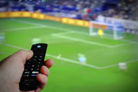 Hand with TV remote control Stock Photos