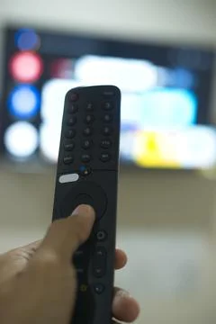 Hand with TV remote control, switching TV series from streaming service pla.. Stock-Fotos