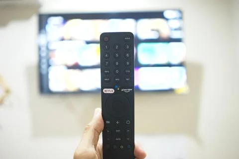 Hand with TV remote control, switching TV series from streaming service pla.. Stock Photos