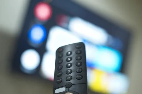 Hand with TV remote control, switching TV series from streaming service pla.. Stock Photos