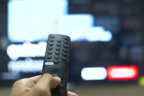Hand with TV remote control, switching TV series from streaming service pla.. Stock Photos