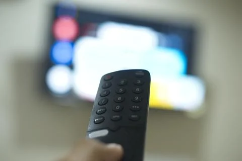 Hand with TV remote control, switching TV series from streaming service pla.. Stock Photos