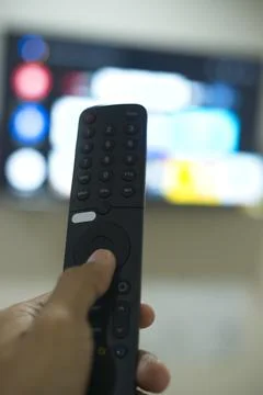 Hand with TV remote control, switching TV series from streaming service pla.. Stock Photos