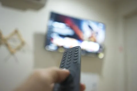 Hand with TV remote control, switching TV series from streaming service pla.. Stock Photos