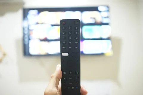 Hand with TV remote control, switching TV series from streaming service pla.. Foto stock