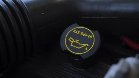 Hand twisting cap and adding oil to engine slow motion Vidéo 107609982