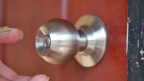 A hand twisting a door knob and opening a door 库存影片 70553239