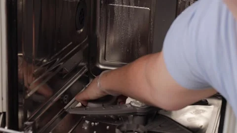 Hand twisting open the cap of the salt reservoir inside a dishwasher, prepa.. Stock Footage 320737918