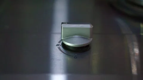 Hand twisting stove dial to activate gas burner flame. Stock Footage 344011584