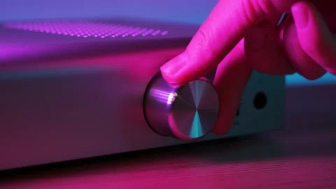 Hand twists the amplifier button. Female turn on tumbler increasing music Stock Footage 140579761