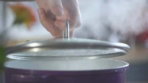 Hand twists cap on a pot of boiling water in a restaurant. Food on cuisine. Vidéo 124709062