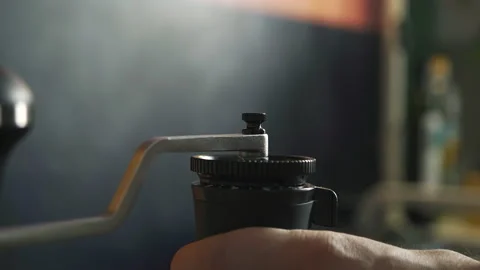 Hand twists the handle of a mechanical coffee grinder in the kitchen at home Stock Footage 171154920