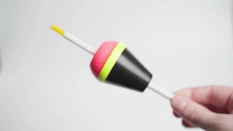 A hand twists a large float for fishing on a white background close-up. Easily Stock Footage 171851212
