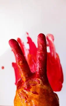 Hand - two fingers in multi-colored paint on a white background with spots. Stock Photos