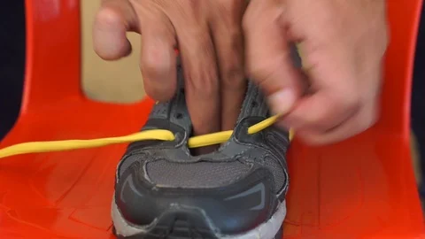 The hand is tying the shoe strap. Stock Footage 96999836