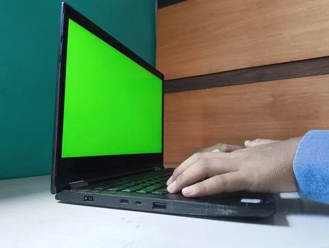 Hand types on keyboard with green screen display Stock-Fotos