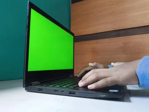 Hand types on keyboard with green screen display Foto stock
