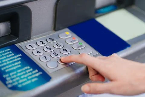 The hand types the pin code on the ATM keyboard. Foto stock