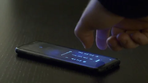 A hand types a pin code on a mobile phone, volumetric lights shoot out and Stock Footage 100239504