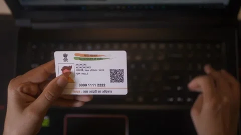 Hand typing Aadhaar Card identification number for tatkal railway ticket booking Stock Footage 311641800