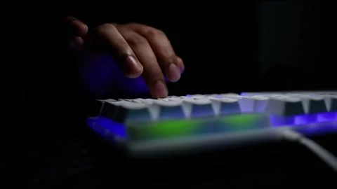 Hand Typing on Backlit Keyboard in Dark Room Stock Footage 318056697