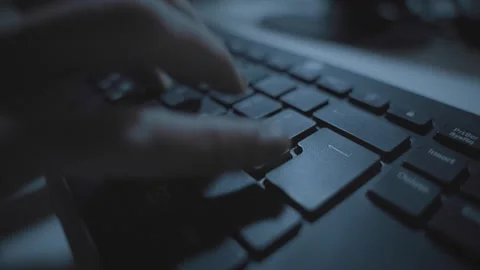 Hand typing in dark office desk on computer keyboard pressing on return or Stock Footage 332964805