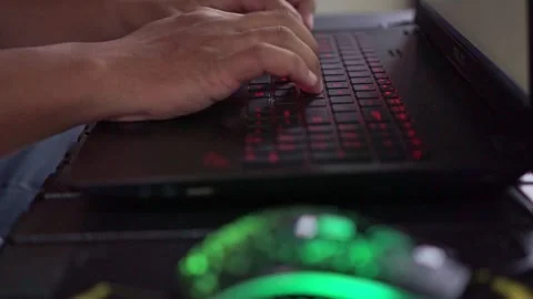 Hand typing on illuminated laptop keys with glowing mouse on the side, Stock Footage 334420683