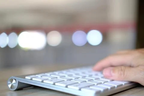 Hand typing on a laptop computer at a desk in close-up Stock-Fotos
