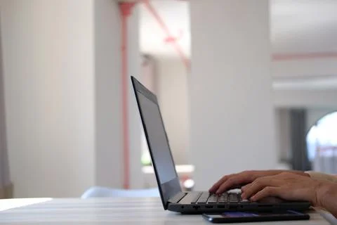 Hand typing on a laptop computer at a desk in close-up Stock Photos