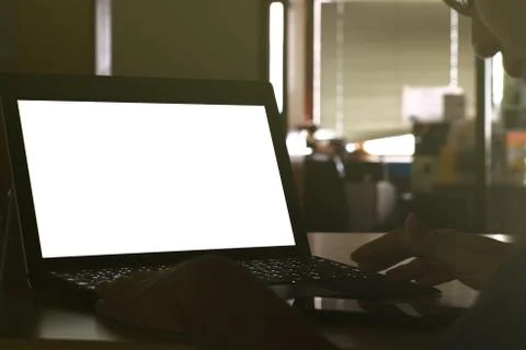 Hand typing on Laptop computer Keyboard displaying white background. PC on a Stock Photos