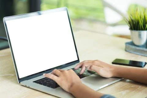 Hand typing laptop computer showing blank screen on table office place Foto stock