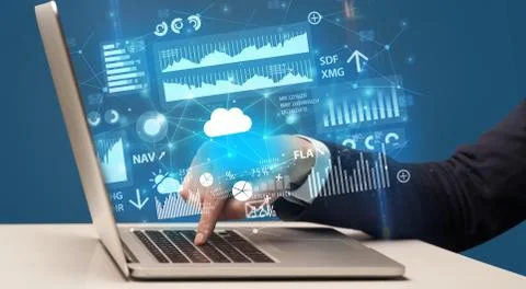 Hand typing on laptop graphs and charts and reports concept around Foto stock