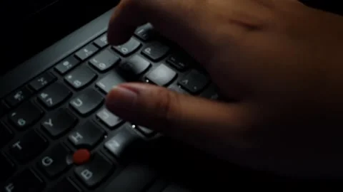 Hand typing on laptop keyboard in low light Vídeo Stock 334087255